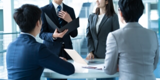 写真：スーツを着たビジネスマンたちが会議を行う様子