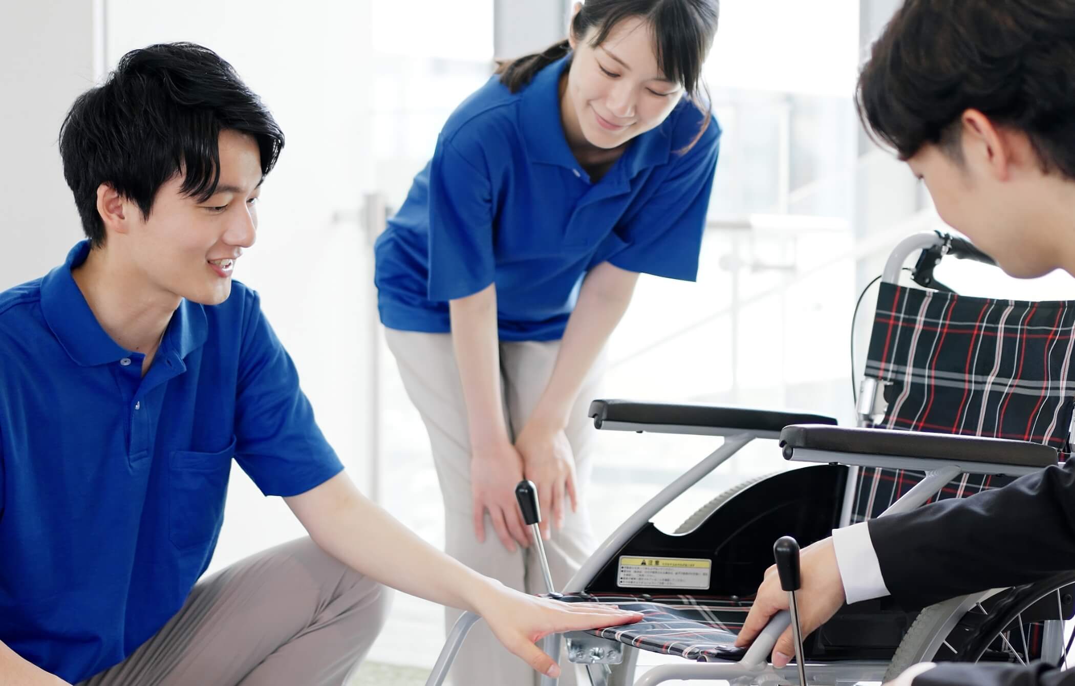 写真：車椅子製品を3人のスタッフが確認し合う様子