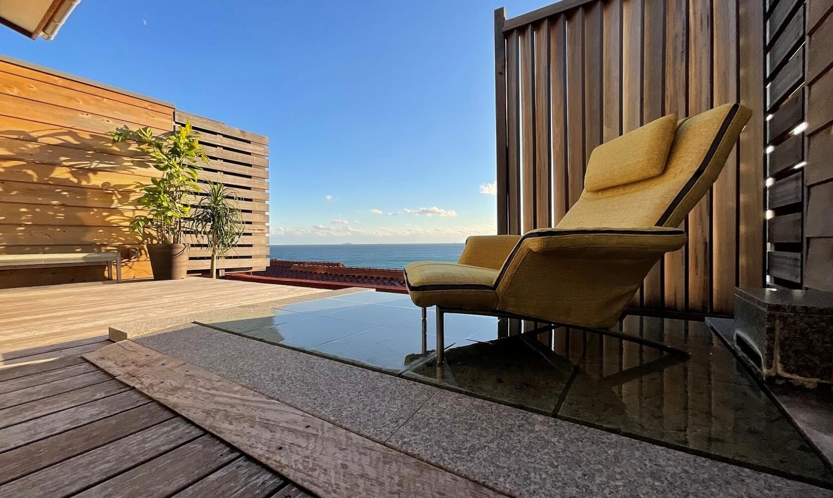 写真：屋外の温泉施設にプルミエを導入した様子。奥には海が広がっている。